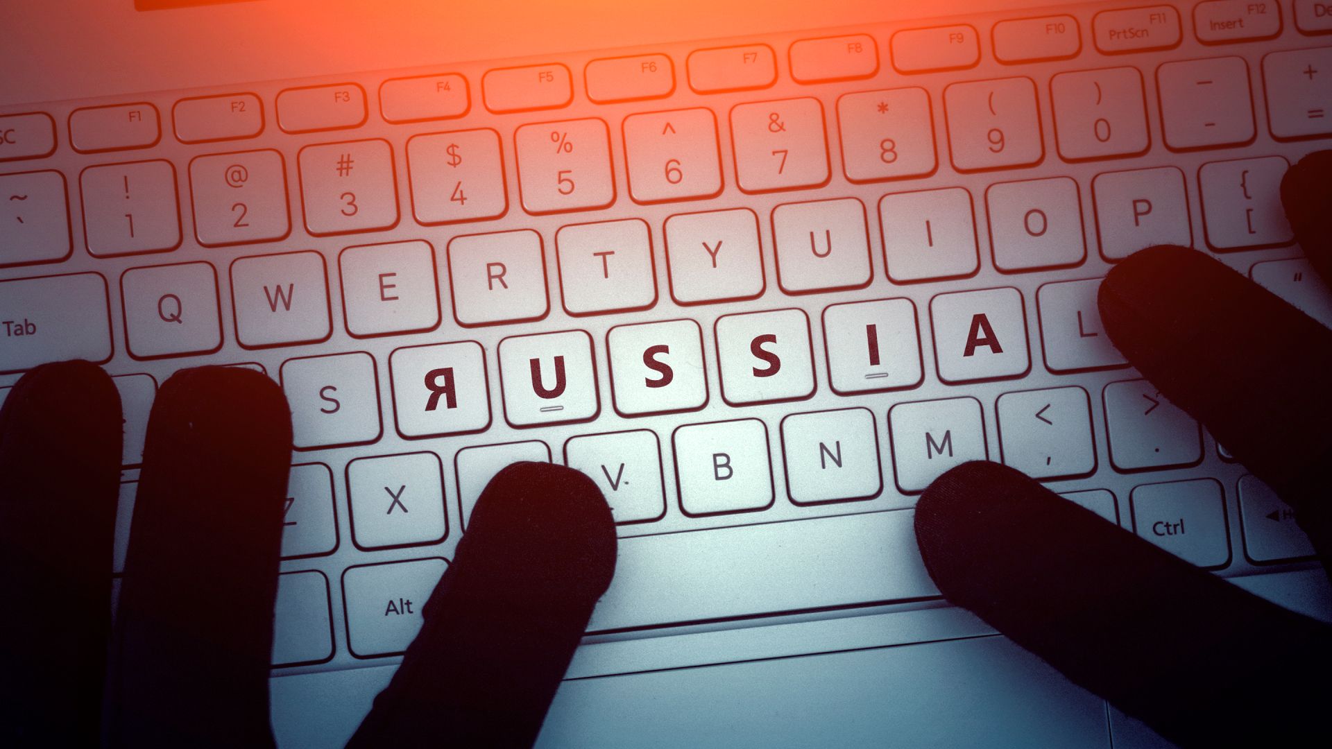 Gloved hands on a keyboard with the word Russia highlighted